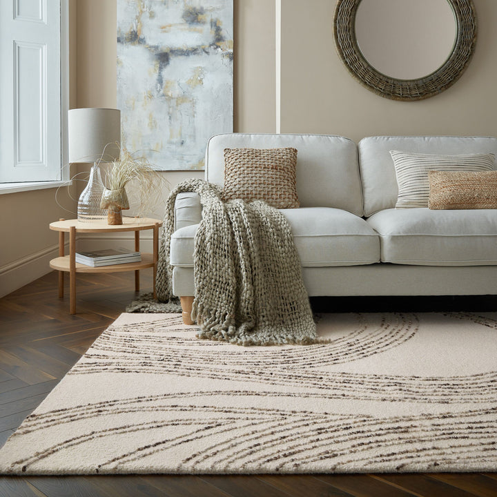 le tapis swirl en coloris marron est présenté dans un salon relaxant devant un canapé#couleur_naturel-marron