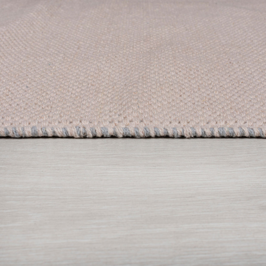 zoom sur la matière et l'épaisseur du tapis enfant pompom rose#couleur_rose